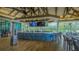 Outdoor bar featuring a blue facade, modern seating, large TV screens and views of the lake at 7849 Wilton Crescent Cir, University Park, FL 34201