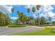 Beautiful clubhouse with a circular drive, mature landscaping and palm trees set against a partly cloudy sky at 7849 Wilton Crescent Cir, University Park, FL 34201