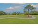 Scenic view of the golf course with lush green fairways, mature trees, and a meandering cart path for a peaceful setting at 7849 Wilton Crescent Cir, University Park, FL 34201