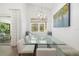 Bright dining room features a glass table, built-in bench seating, and modern chandelier at 8077 Tidal Pointe Way, Sarasota, FL 34240