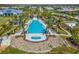 The community's expansive pool features lounge chairs, tropical landscaping, and serene views in this aerial perspective at 8077 Tidal Pointe Way, Sarasota, FL 34240