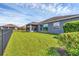 Grassy backyard with a black fence, leading to a screened in patio, offering ample privacy at 815 Rosemary Cir, Bradenton, FL 34212