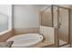The relaxing bathroom showcases a soaking tub and a glass-enclosed shower, all complemented by neutral tile and fixtures at 815 Rosemary Cir, Bradenton, FL 34212