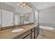 A luxurious bathroom features double sinks, granite counters, a soaking tub, and a glass-enclosed shower at 815 Rosemary Cir, Bradenton, FL 34212