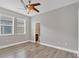 Neutral bedroom features wood-look flooring, ceiling fan, and windows that provide natural light creating a relaxing retreat at 815 Rosemary Cir, Bradenton, FL 34212