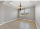 Elegant dining room features a decorative chandelier, tray ceiling, and natural light, perfect for Gathering meals and entertaining guests at 815 Rosemary Cir, Bradenton, FL 34212