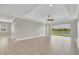 Spacious living room featuring tile flooring, neutral paint, and a tray ceiling with modern fan at 815 Rosemary Cir, Bradenton, FL 34212