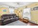 Cozy living room with a comfortable leather sofa, fan, and ample natural light at 818 50Th Avenue W Ter, Bradenton, FL 34207