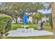 Outdoor barbecue area with table, benches, grill, and a blue umbrella at 102 46Th Avenue W Ter # 402, Bradenton, FL 34207