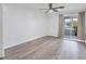 Bright living room with a ceiling fan, wood-look floors, and sliding glass doors to the outside patio at 102 46Th Avenue W Ter # 402, Bradenton, FL 34207
