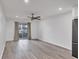 Living room with wood floors, ceiling fan and a view to an outdoor balcony at 102 46Th Avenue W Ter # 402, Bradenton, FL 34207