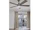 Close up of the bright living room with a ceiling fan, wood-look floors, and sliding glass doors to the outside patio at 102 46Th Avenue W Ter # 402, Bradenton, FL 34207