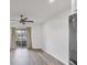 Bright living room with a ceiling fan, wood-look floors, and sliding glass doors to the outside patio at 102 46Th Avenue W Ter # 402, Bradenton, FL 34207