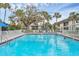 Community pool with chairs and palm tree views at 102 46Th Avenue W Ter # 402, Bradenton, FL 34207