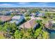 Aerial view of the neighborhood showcasing a house with lush landscaping by the water at 12026 Perennial Pl, Bradenton, FL 34211