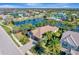 Stunning aerial view of a lakeside home with lush landscaping and a resort-style community pool at 12026 Perennial Pl, Bradenton, FL 34211
