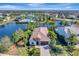 Aerial view of home and surrounding community with pool, pond, and palm trees at 12026 Perennial Pl, Bradenton, FL 34211