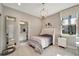 Cozy bedroom with wood floors, a comfortable bed, a bathroom and a window providing natural light at 12026 Perennial Pl, Bradenton, FL 34211