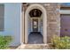 Arched entrance features a stone wall, tiled floor, and a glimpse of the front door with glass inserts at 12026 Perennial Pl, Bradenton, FL 34211