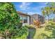 Exterior shot of home with screen porch, well-maintained landscaping, and blue sky at 12026 Perennial Pl, Bradenton, FL 34211