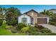 Charming single-story home with stone facade, arched entryway, and lush, well-maintained landscaping at 12026 Perennial Pl, Bradenton, FL 34211