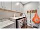 Functional laundry room featuring a sink, counter space, washing machine, dryer, and storage cabinets at 12026 Perennial Pl, Bradenton, FL 34211