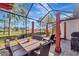 Enjoyable screened patio with dining table, lounge chairs, and lake views at 12026 Perennial Pl, Bradenton, FL 34211