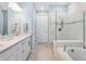 Bright bathroom features white cabinets, marble counters, bathtub, and tiled glass enclosed shower at 12404 Golden Sage Dr, Sarasota, FL 34238
