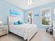 Bright bedroom features blue walls, tiled flooring, white furniture, and natural light at 12404 Golden Sage Dr, Sarasota, FL 34238