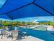 Bocce ball court with covered seating area surrounded by lush landscaping and blue sky at 12404 Golden Sage Dr, Sarasota, FL 34238