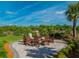 Cozy outdoor fire pit surrounded by comfortable Adirondack chairs and lush landscaping at 12404 Golden Sage Dr, Sarasota, FL 34238