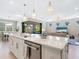 Open concept kitchen with island seating, modern lighting, and sliding doors to the outdoor living space at 12404 Golden Sage Dr, Sarasota, FL 34238