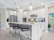 Bright kitchen with white cabinetry, a large island with seating, and modern stainless steel appliances at 12404 Golden Sage Dr, Sarasota, FL 34238
