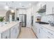Bright kitchen features stainless steel appliances, white cabinets, stone countertops, and stylish pendant lighting at 12404 Golden Sage Dr, Sarasota, FL 34238