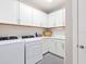 Laundry room with new washer and dryer machines and white cabinets at 12404 Golden Sage Dr, Sarasota, FL 34238