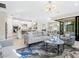 Open-concept layout with gray sofa, tile floors, and ample natural light, flowing to a modern kitchen at 12404 Golden Sage Dr, Sarasota, FL 34238