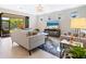 A cozy living room featuring neutral decor, tile floors, and natural light coming from a sliding glass door at 12404 Golden Sage Dr, Sarasota, FL 34238