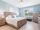 Tranquil bedroom features neutral paint, tiled floor, light colored furniture, and a window at 12404 Golden Sage Dr, Sarasota, FL 34238