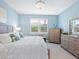 Bright bedroom with tiled floors, white bedding, window, and matching dresser at 12404 Golden Sage Dr, Sarasota, FL 34238