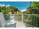 Cozy balcony with white chairs and a view of lush tropical landscaping and community homes at 130 50Th St, Holmes Beach, FL 34217