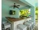 Outdoor bar area with countertop, sink, television and seating for a relaxed atmosphere at 130 50Th St, Holmes Beach, FL 34217
