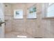 Bright bathroom featuring a tiled walk-in shower and two windows at 130 50Th St, Holmes Beach, FL 34217