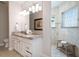 Bright bathroom featuring double sinks with granite counters, a mirror, and a tiled walk-in shower at 130 50Th St, Holmes Beach, FL 34217