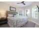 This bright bedroom has neutral walls, shutters, a ceiling fan, and a TV at 130 50Th St, Holmes Beach, FL 34217