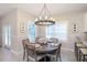 Cozy dining room with wood table set for six, modern chandelier, and bright windows at 130 50Th St, Holmes Beach, FL 34217