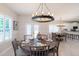 Bright dining room features a rustic chandelier and seating for six near the open concept kitchen at 130 50Th St, Holmes Beach, FL 34217