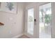 Bright entryway features a white paneled door with blinds, leading to a charming and well-maintained home at 130 50Th St, Holmes Beach, FL 34217