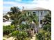 Charming two-story home with a turquoise exterior, lush landscaping and a private balcony, perfect for coastal living at 130 50Th St, Holmes Beach, FL 34217
