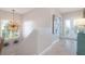 Light and bright hallway with tile flooring, a unique chandelier, and stairs at 130 50Th St, Holmes Beach, FL 34217