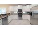 Bright kitchen featuring white cabinetry, stainless steel appliances, and granite countertops at 130 50Th St, Holmes Beach, FL 34217